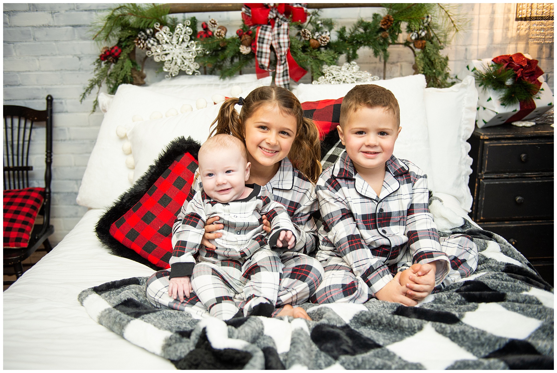 young children posing on bed during holiday photos in Knoxville TN