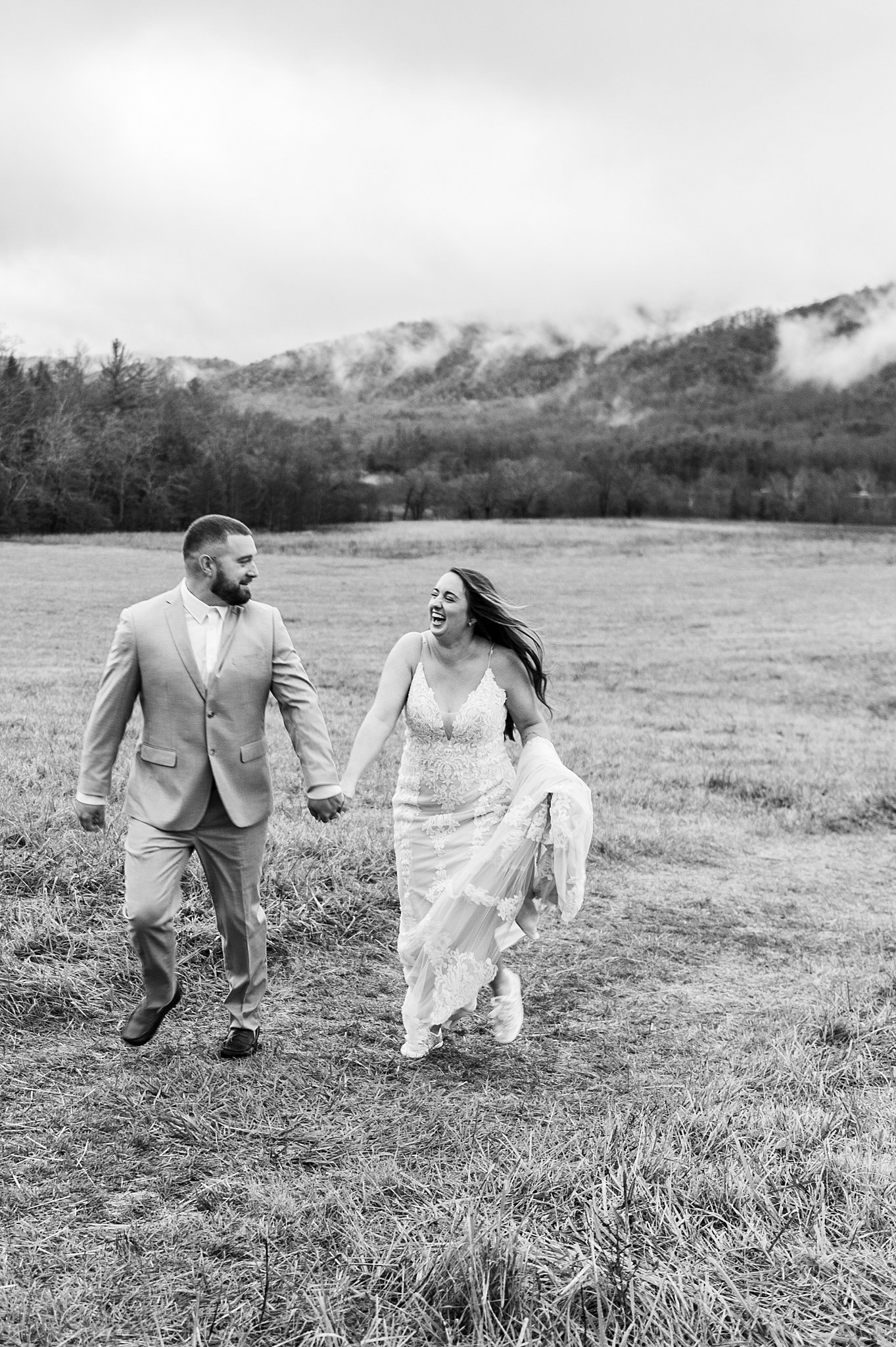 Elope In The Smoky Mountains. 
Bride and groom running through a field in Cades Cove after they eloped.