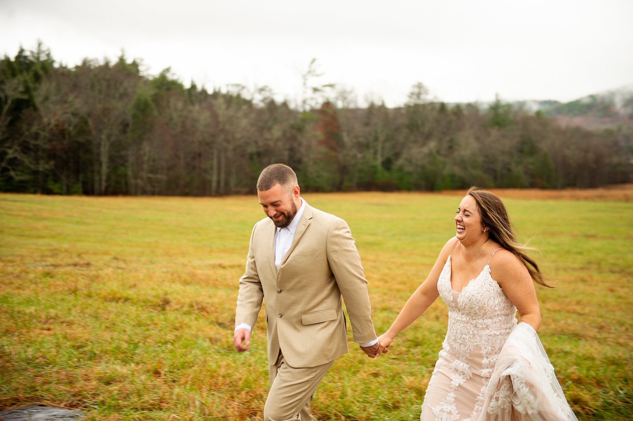 bride and groom running through a field in Cades Cove