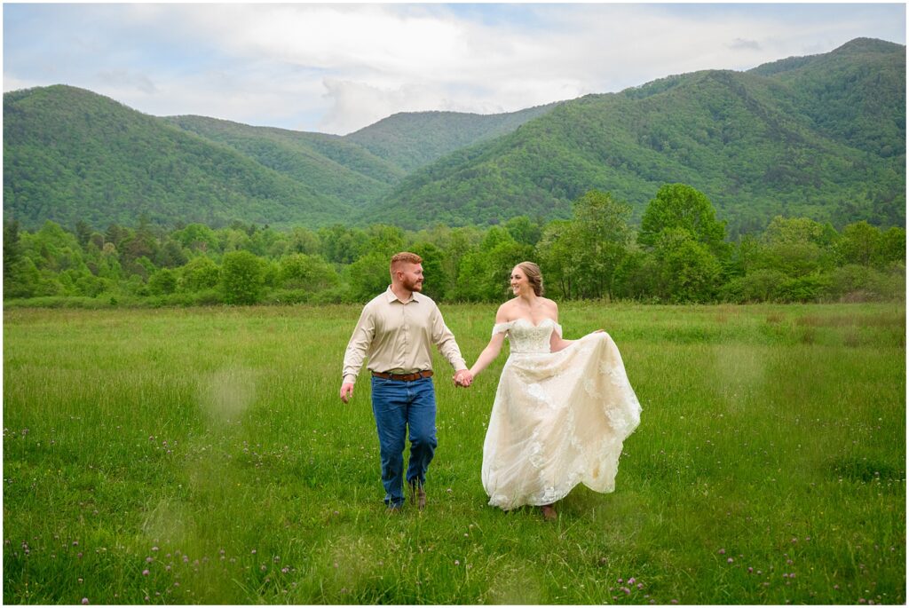 bride and groom walking through a field in Cades Cove in the smoky mountains national park